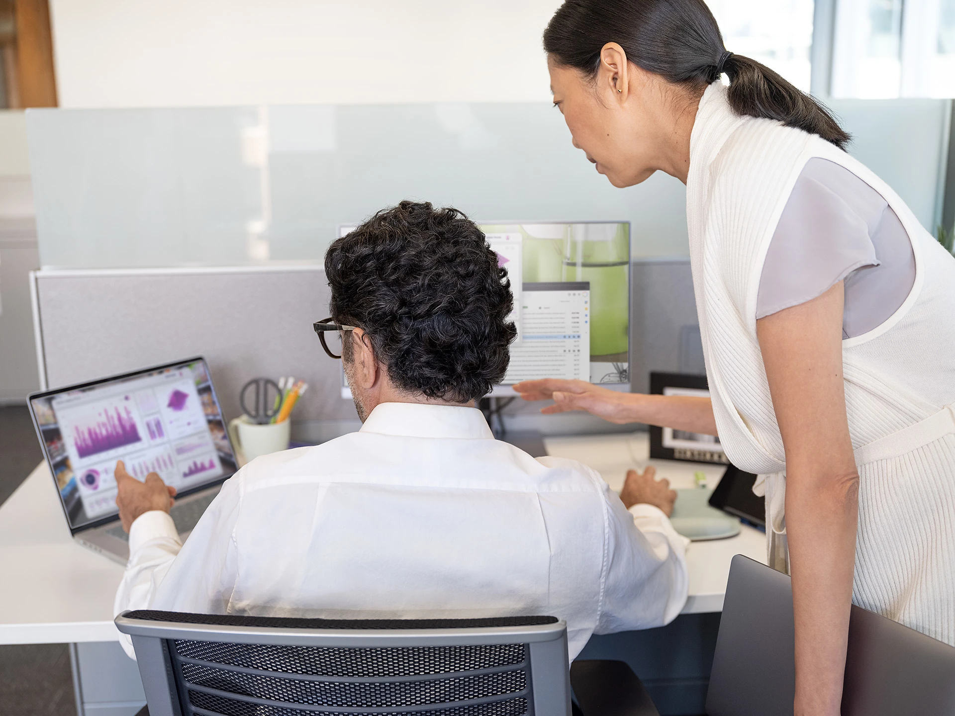 A man and a woman engage in a productive session at a computer, discussing in-season agriculture data.