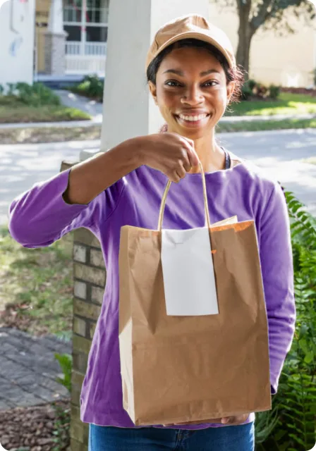 A food delivery person is at the door with an order.