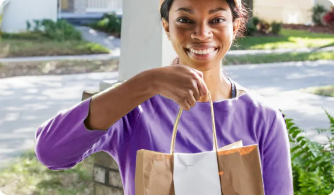 A food delivery person is at the door with an order.