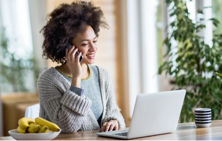 Woman on phone while working on laptop