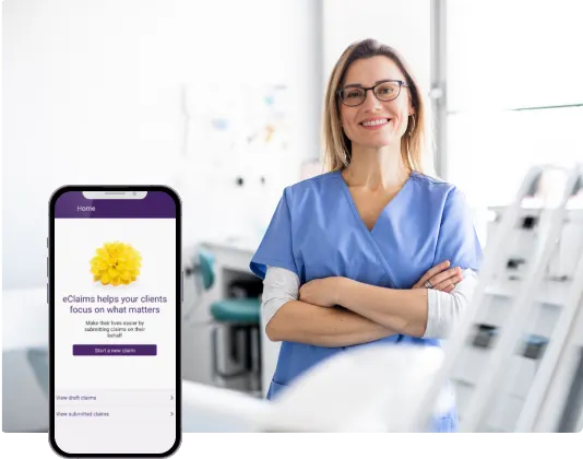 a woman standing in a dental office with a cell phone showing the adjudicare interface