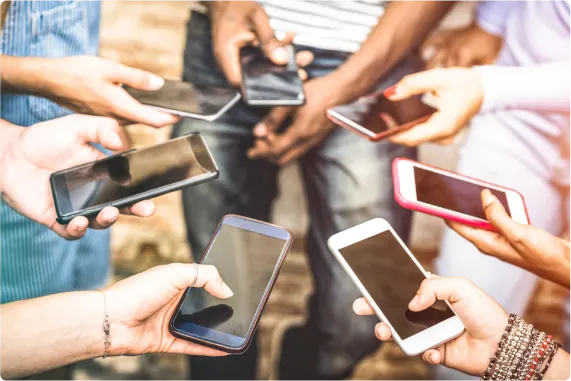 A shot of eight hands in a circle, each holding a smartphone