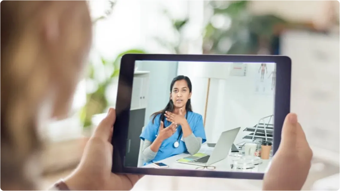 A woman speaking with a healthcare professional on her tablet.