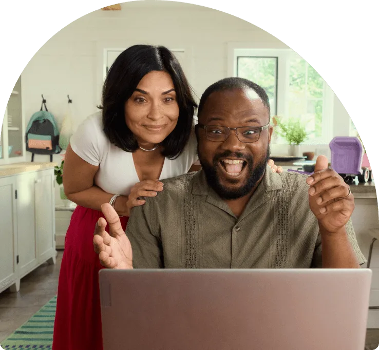 A couple viewing their laptop in excitement.